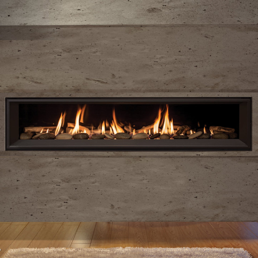 Enviro C Series linear gas fireplace with black glass liner and river rock media