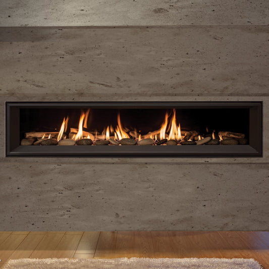 Enviro C Series linear gas fireplace with black glass liner and river rock media